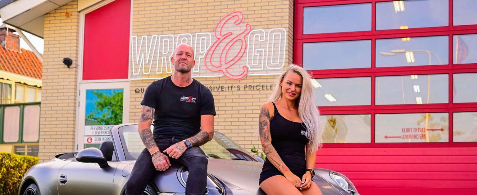 Martin en Michella voor pand zittend op Porsche