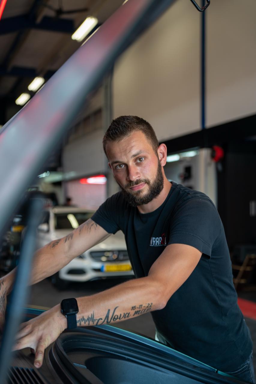 medewerker Kevin bij open motorkap